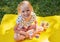 Happy smiling child girl drinking yogurt or milk outdoor at a summer picnic. Holding white plastic bottle and on face whiskers