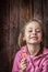 Happy smiling child girl with lollipop on rustic wood background