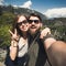 Happy smiling couple of students in love take selfie self-portrait while hiking in Yosemite National Park, California