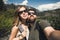 Happy smiling couple of students in love take selfie self-portrait while hiking in Yosemite National Park, California