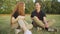 Happy smiling couple of teenagers talking sitting on summer meadow and falling back on grass. Positive Caucasian boy and