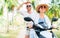 Happy smiling couple travelers riding motorbike scooter under palm trees. Thailand tropical vacation concept image