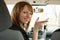 Happy smiling driver woman showing car key sitting in a new auto