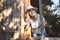 Happy smiling emotional elderly woman having fun posing by open window in rustic old wooden village house in straw hat. Retired