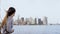 Happy smiling European woman with flying hair enjoying famous Manhattan skyline view in New York from a tourist boat.