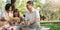 happy smiling family grandparent and grandchild picnic together outside at park