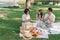 happy smiling family grandparent and grandchild picnic together outside at park