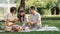 happy smiling family grandparent and grandchild picnic together outside at park