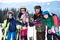 Happy smiling family on skis and snowboard in deep snow on background of winter mountains.