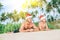 Happy smiling father and son in Santa hats have sun bath on sandy island beach