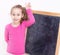 Happy smiling five years old child girl in front of blackboard