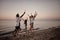 Happy smiling friends running at the beach with sparkling candles