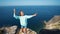 Happy smiling girl in bright blue sweatshirt and jeans shorts making selfie on cliff edge