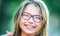 Happy smiling girl with dental braces and glasses. Young cute caucasian blond girl wearing teeth braces and glasses