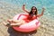 Happy Smiling girl enjoys floating on inflatable donut in sea. vacation time