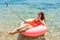Happy Smiling girl makes selfie floating on inflatable donut in sea. vacation time