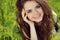 Happy smiling girl resting on green grass, outdoors portrait