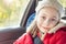 Happy smiling girl traveling in a car during autumn