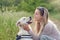 Happy smiling golden dog wearing a walking harness sitting facing its pretty young woman owne