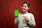 Happy smiling Indian girl in ethnic dress Pointing finer to mobile phone with mock up green screen for Diwali festival