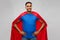 Happy smiling indian man in red superhero cape