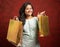 Happy Smiling Indian woman with shopping bags looking at camera - concept showing of shopaholic and holiday festival shopping