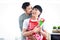 Happy smiling LGBT couple hug and kiss, share sweet moment together on Valentine Day at kitchen, Asian gay male lover give red