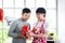 Happy smiling LGBT couple share special moment together on Valentine Day at kitchen, Asian gay male lover give red gift box