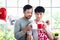 Happy smiling LGBT couple sharing special moment together on Valentine Day, Asian gay male lover drinking hot beverage coffee at