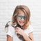 Happy smiling little caucasian girl in glasses with some kitties playing on kid shoulders