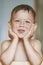 Happy Smiling Little Caucasian Tanned Boy With Hands LIfted. Touching Face.