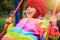 Happy smiling little girl riding on swing. Playful baby on carousel. Little child rides on swing on playground