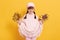 Happy smiling little girl wearing cap looking directly at camera with cute smile, holding bouquets with autumn leaves in both