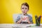 Happy smiling little preschool boy shows letters at home making homework at the morning before the school starts. English learning