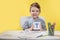 Happy smiling little preschool boy shows letters at home making homework at the morning before the school starts. English learning