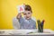 Happy smiling little preschool boy shows letters at home making homework at the morning before the school starts. English learning