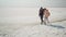 happy smiling lovely couple travelers walking hugging each other on deserted pink white salty coast