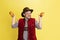 Happy smiling man dressed in traditional Bavarian costume with yummy pretzels isolated over yellow background. National