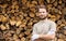 Happy smiling man in front of stacked chopped firewood