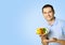 Happy smiling man with plate of salad, bright blue background, mock up copy space. Dieting and healthy eating