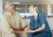 A happy smiling man and woman showing the bond between patient and doctor during a checkup at home. A doctor showing