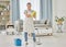 A happy smiling mixed race woman cleaning the floor of her apartment. One Asian woman using a broom and a bucket of