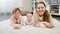 Happy smiling mother with baby and older son lying on soft carpet at living room. Parenting, children happiness and