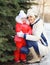 Happy smiling mother and child near christmas tree in winter