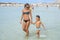 Happy smiling mother and her son playing and running on the beach. Concept of friendly family. Happy summer days. Balos Lagoon