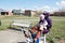 Happy smiling mother and little girl outdoor workout together on trainer outside in early spring nature park. Sport, maternity