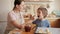 Happy smiling mother with little son eating sweet jam from jar while baking biscuits at home. Children cooking with