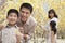 Happy, smiling parents with two children enjoying the park in springtime and looking at flowers