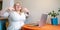 Happy smiling plus-size woman sitting at table with laptop enjoy her coffee break at home working place