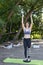 Happy smiling sports girl stands on balancing disc. Fitness in the morning in the park. Outdoor sports